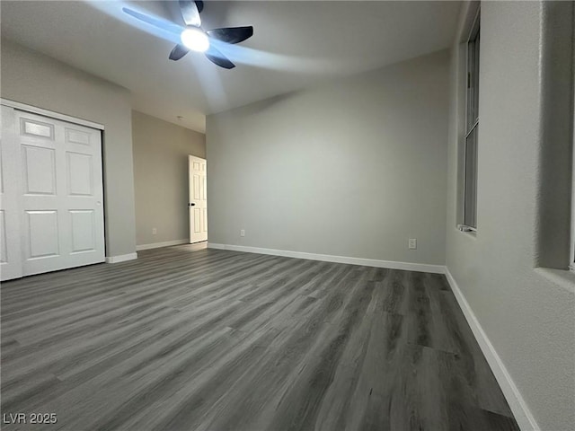 unfurnished bedroom with dark wood-type flooring, ceiling fan, and a closet