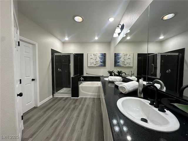 bathroom featuring independent shower and bath, hardwood / wood-style floors, and vanity