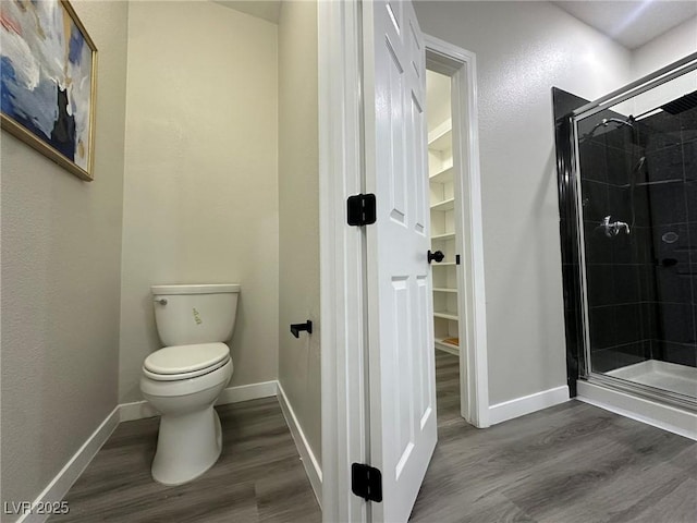 bathroom featuring toilet, wood-type flooring, and an enclosed shower