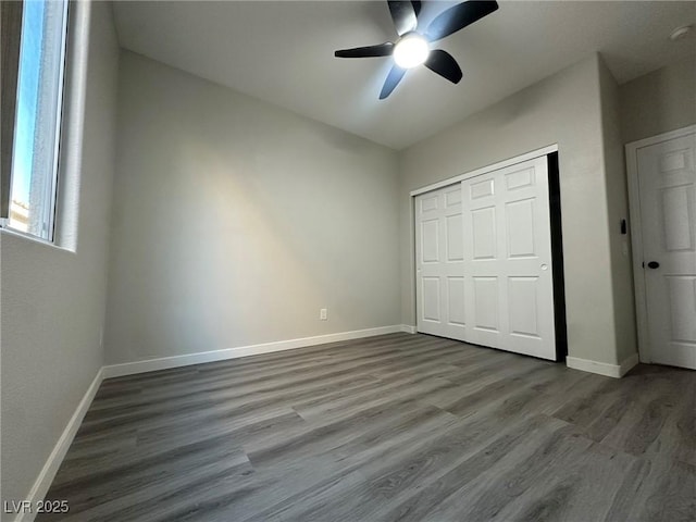 unfurnished bedroom featuring ceiling fan, a closet, and hardwood / wood-style floors