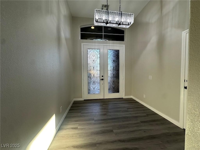 entryway with french doors, a chandelier, and hardwood / wood-style flooring