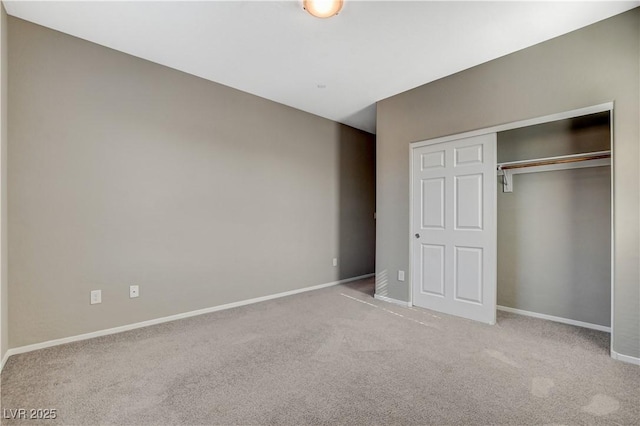 unfurnished bedroom featuring light colored carpet and a closet