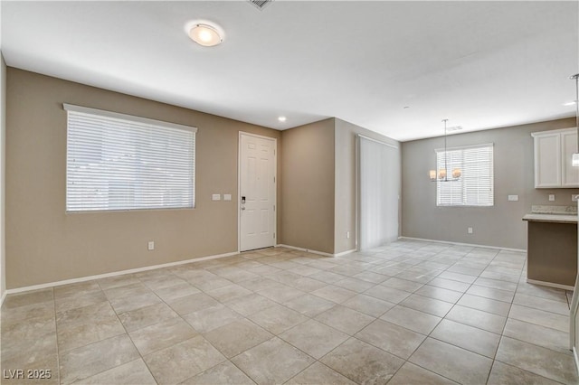 unfurnished room featuring light tile patterned floors and an inviting chandelier