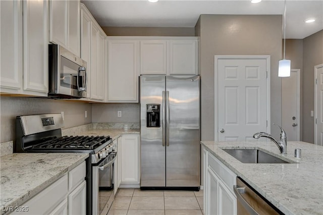 kitchen featuring appliances with stainless steel finishes, white cabinets, decorative light fixtures, and sink