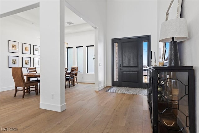 foyer with a high ceiling and light hardwood / wood-style flooring