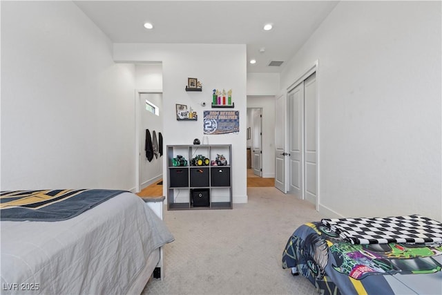 bedroom featuring a closet and light colored carpet