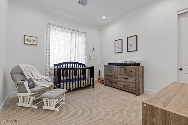 carpeted bedroom featuring a nursery area