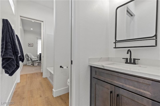 bathroom featuring hardwood / wood-style flooring, toilet, and vanity