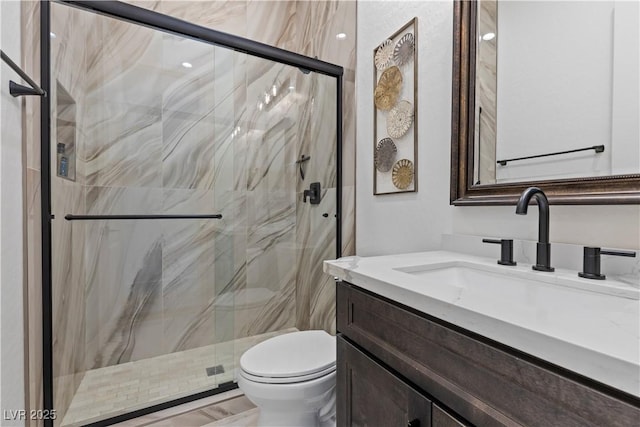 bathroom featuring toilet, a shower with door, and vanity