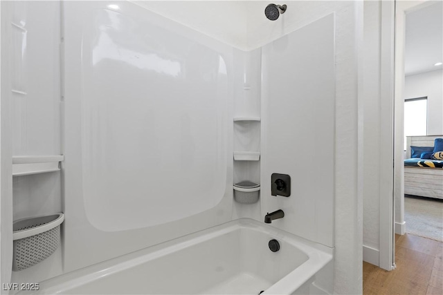 bathroom featuring hardwood / wood-style flooring and washtub / shower combination