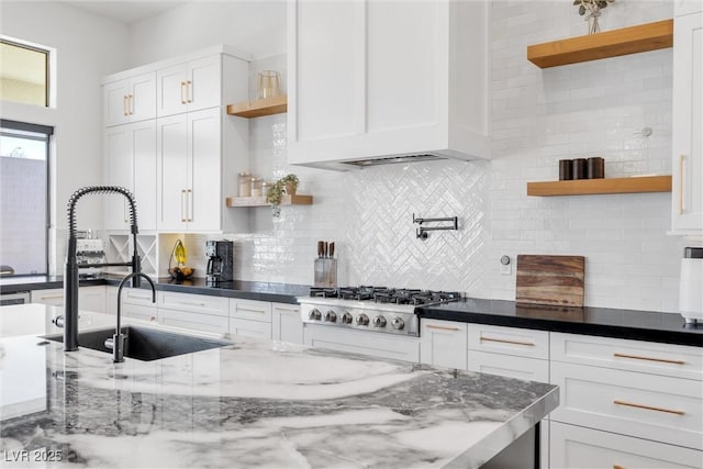 kitchen featuring white cabinetry, decorative backsplash, dark stone counters, and stainless steel gas cooktop