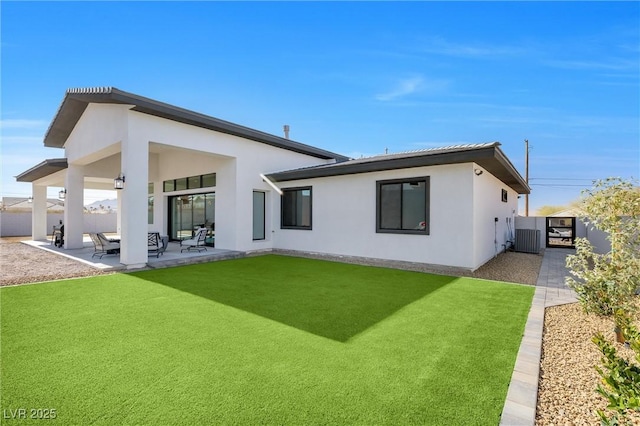 rear view of house featuring a patio area, a lawn, and central air condition unit