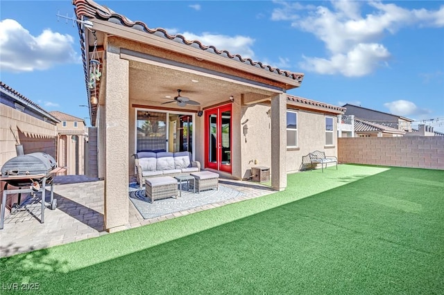 back of house featuring ceiling fan, an outdoor living space, and a patio area