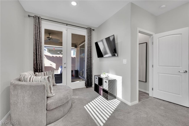 living room featuring ceiling fan, light colored carpet, and french doors