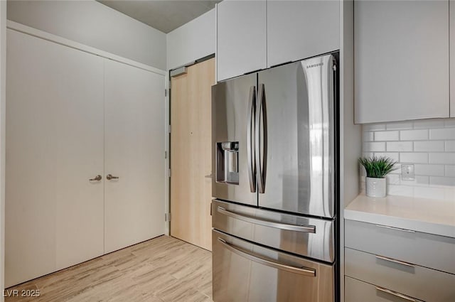 kitchen with stainless steel refrigerator with ice dispenser and decorative backsplash