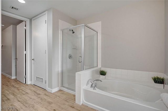 bathroom with wood-type flooring and plus walk in shower