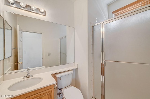 bathroom featuring toilet, a shower with shower door, and vanity