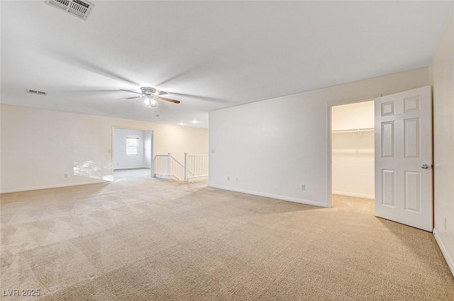 spare room with ceiling fan and light carpet