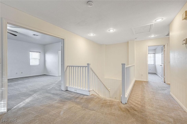 corridor featuring a wealth of natural light and light carpet