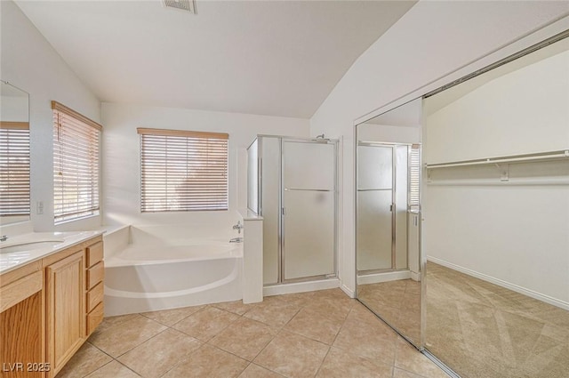 bathroom featuring shower with separate bathtub, tile patterned flooring, vanity, and vaulted ceiling