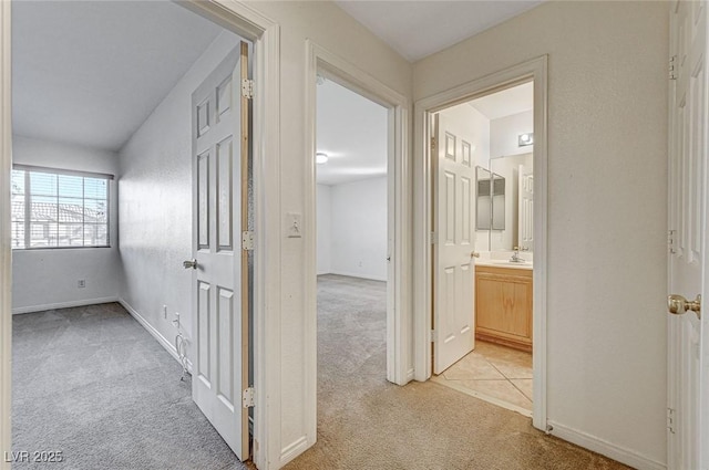 corridor with light colored carpet and sink