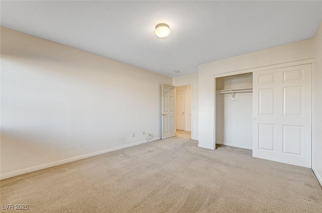 unfurnished bedroom with light carpet and a closet