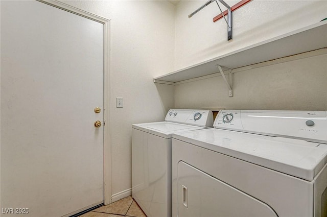 clothes washing area with separate washer and dryer and light tile patterned floors