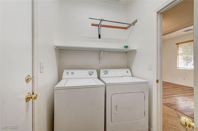 washroom with washer and clothes dryer and light hardwood / wood-style flooring