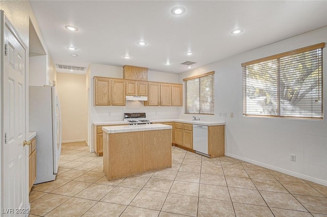 kitchen featuring light tile patterned floors, sink, white appliances, and a center island