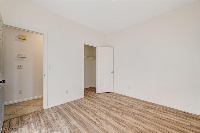 unfurnished bedroom featuring light hardwood / wood-style flooring and a closet