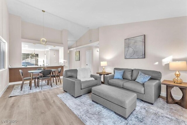 living room with light hardwood / wood-style flooring and vaulted ceiling