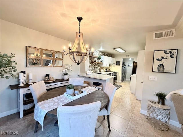 dining room with an inviting chandelier, light tile patterned floors, and sink