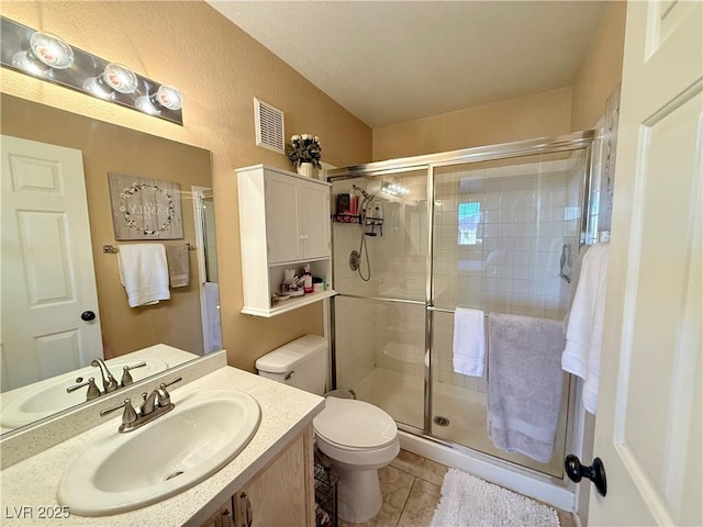 bathroom with toilet, a shower with door, vanity, and tile patterned flooring