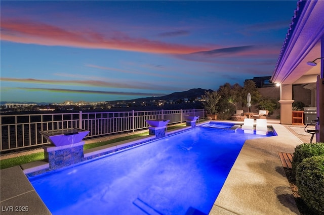 pool at dusk with a patio area and a grill