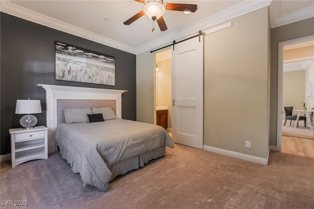 carpeted bedroom featuring ornamental molding, ensuite bath, ceiling fan, and a barn door