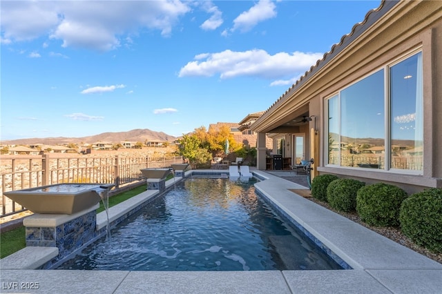 view of pool with a mountain view, a patio area, and pool water feature