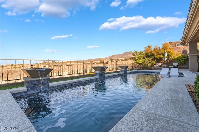 view of pool featuring a mountain view, a patio area, and pool water feature