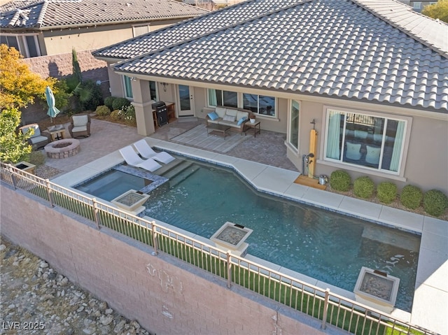 view of pool featuring an in ground hot tub, a patio, grilling area, and an outdoor living space with a fire pit