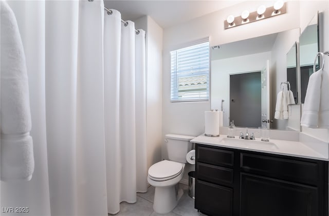 bathroom featuring toilet, vanity, and tile patterned flooring