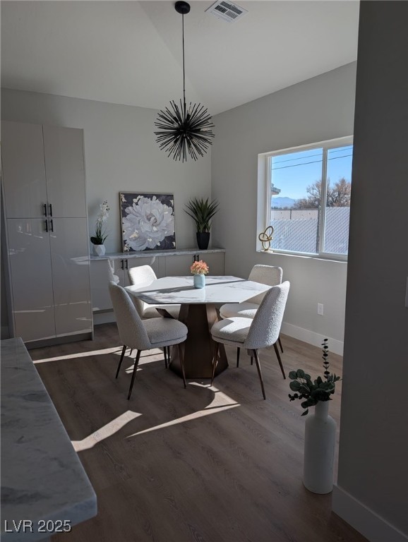 dining area featuring vaulted ceiling and dark hardwood / wood-style floors