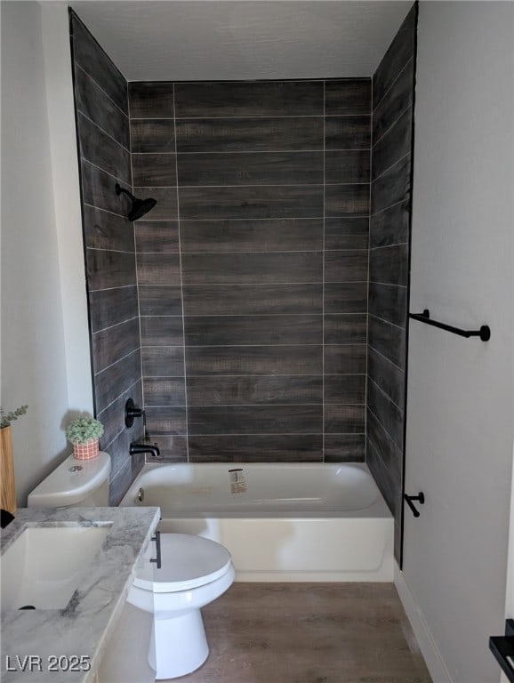 full bathroom with vanity, hardwood / wood-style flooring, toilet, and tiled shower / bath