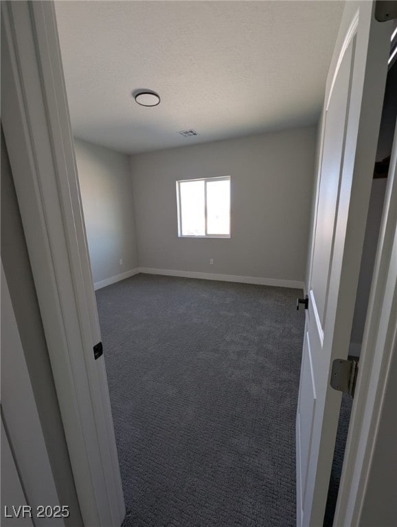 carpeted spare room with a textured ceiling