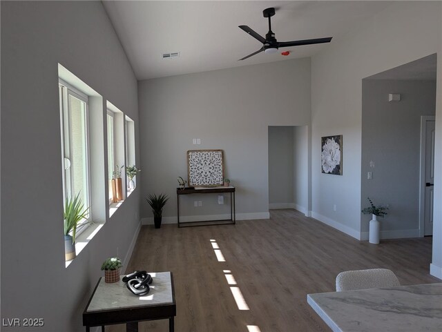 unfurnished living room with ceiling fan, high vaulted ceiling, and hardwood / wood-style floors