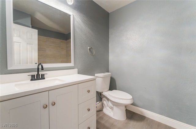 bathroom featuring wood-type flooring, vanity, and toilet