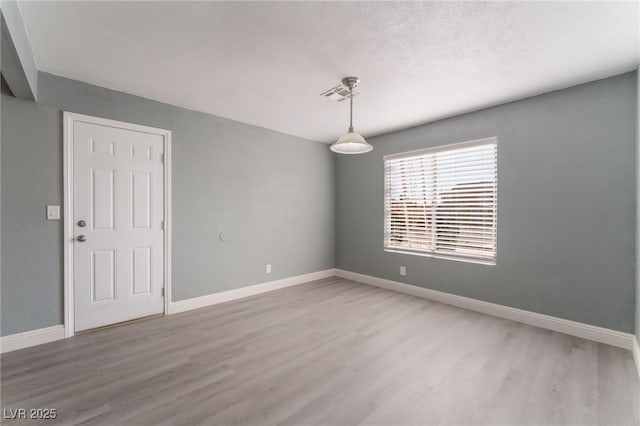 unfurnished room with hardwood / wood-style floors and a textured ceiling