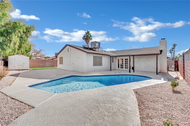 view of pool with french doors, a patio, and a storage unit