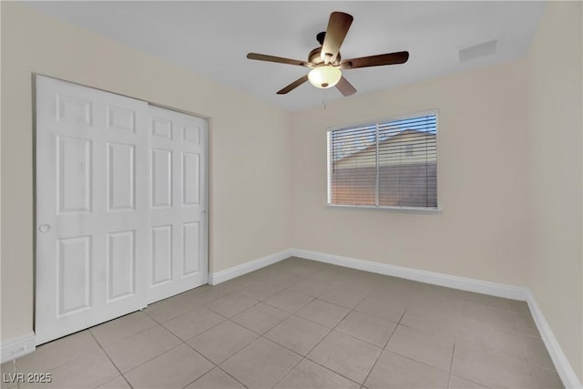 unfurnished bedroom featuring light tile patterned flooring, ceiling fan, and a closet