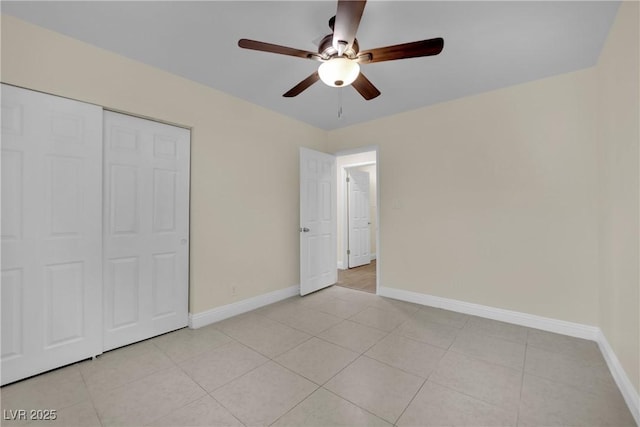 unfurnished bedroom with light tile patterned flooring, ceiling fan, and a closet