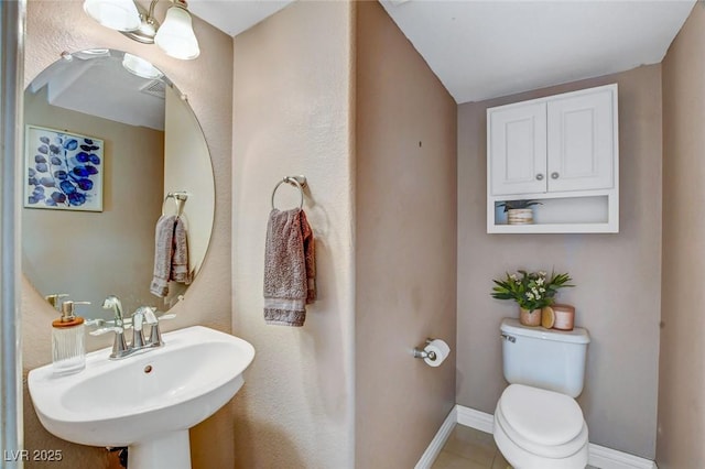 bathroom featuring tile patterned floors, toilet, and sink