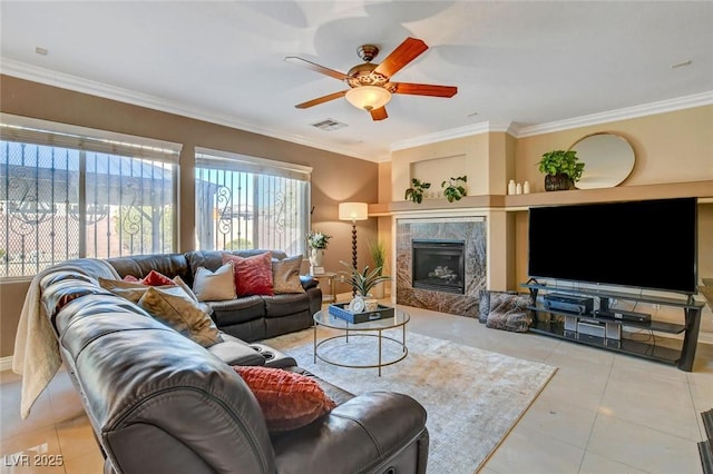 tiled living room featuring ornamental molding, ceiling fan, and a fireplace